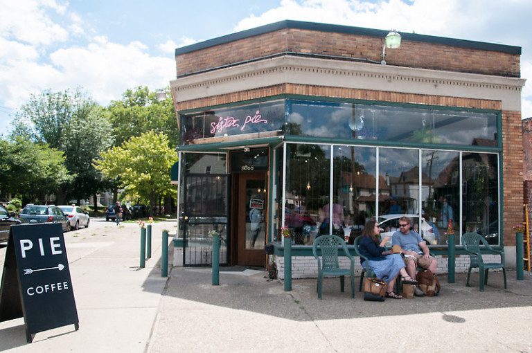 Photo of the side facade of the Sister Pie cafe on a sunny day with people sitting outside.