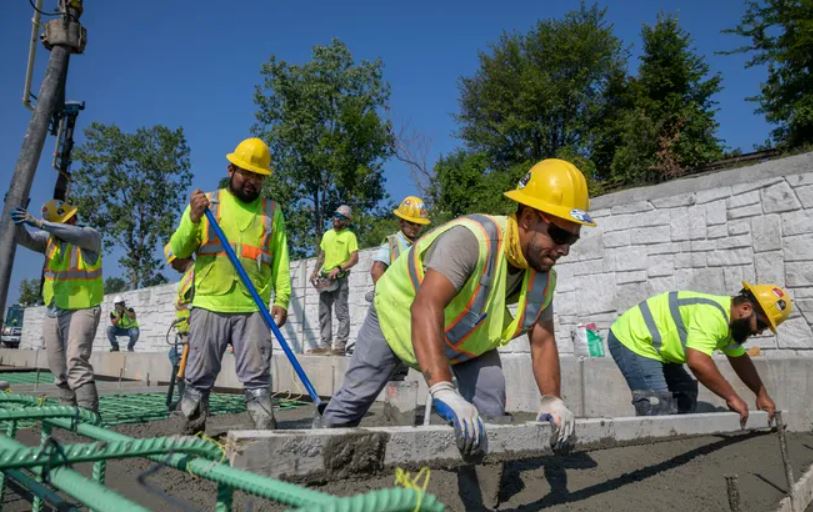 Construction workers smooth out the poured concrete